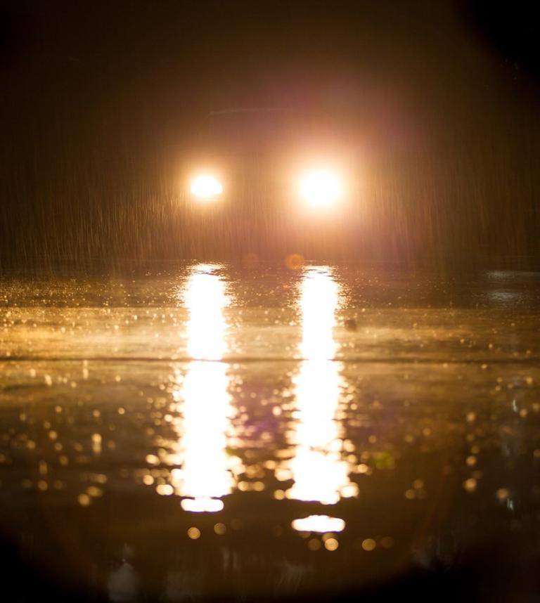 Late night drive through city with reflections of headlights