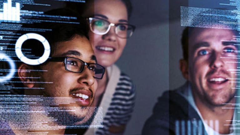 Three people viewed digital screens showing data visualizations