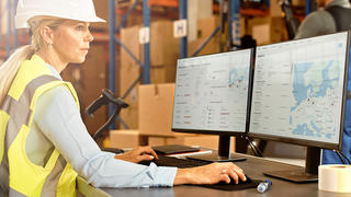 Warehouse worker at a workstation tracking assets in real-time with an end-to-end solution